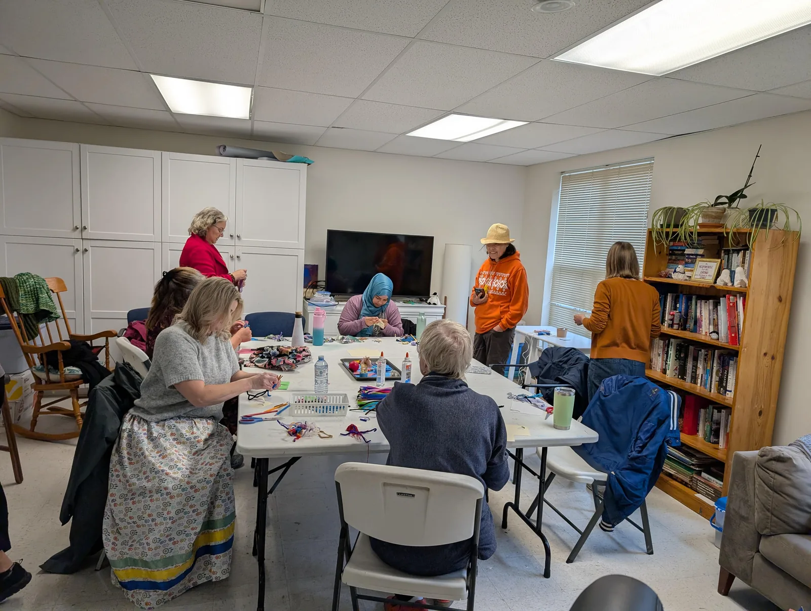 Participants seated together at a large table during a Wellness Gathering craft activity.