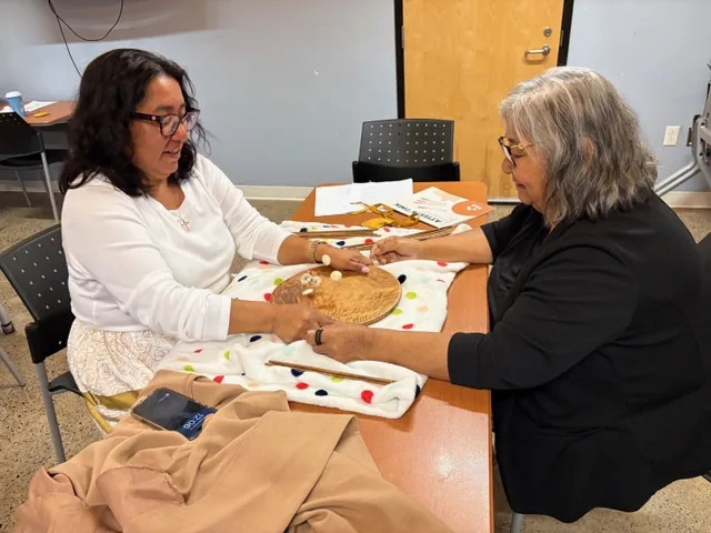 Participants playing a dice and bowl game at a table during the Wellness Gathering.